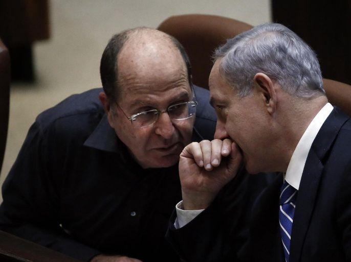 Israeli Prime Minister Benjamin Netanyahu (R) discusses with Israeli Defense minister Moshe Yaalon before the ultimate vote to dissolve the Israeli Parliament at the Knesset on December 8, 2014 in Jerusalem. Netanyahu tore apart his fractious coalition government by firing two centrist ministers the presvious week and calling for the early polls. AFP PHOTO / THOMAS COEX