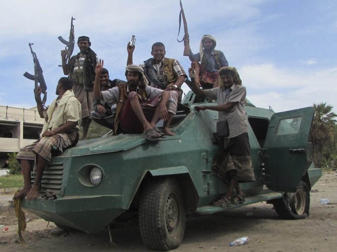 In this photo taken on Friday, March 20, 2015, militiamen loyal to President Abed Rabbo Mansour Hadi ride on an army vehicle on a street in Aden, Yemen. The country's Shiite rebels issued a call to arms Saturday to battle forces loyal to the embattled President Hadi, as U.S. troops evacuated a southern air base over al-Qaida militants seizing a nearby city, authorities said. (AP Photo/Yassir Hassan)