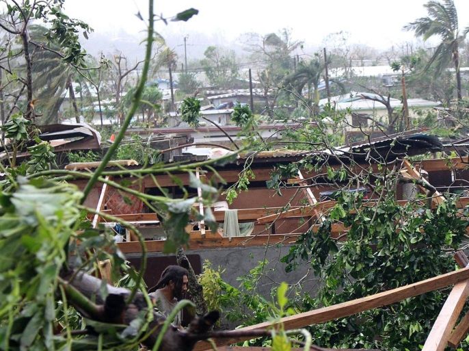 In this photo provided by non-governmental organization 350.org, debris is scattered over a building in Port Vila, Vanuatu, Saturday, March 14, 2015, in the aftermath of Cyclone Pam. Winds from the extremely powerful cyclone that blew through the Pacific's Vanuatu archipelago are beginning to subside, revealing widespread destruction. (AP Photo/350.org, Isso Nihemi ) EDITORIAL USE ONLY, NO SALES