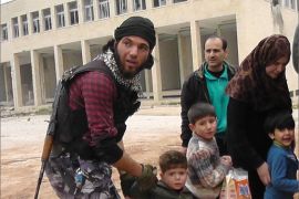 عناصر الجيش الحر تساعد المدنيين على النزوح من مدينة إدلب.jpg