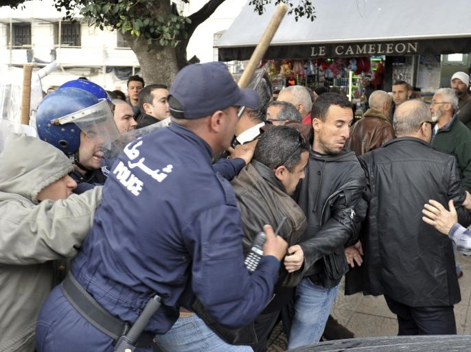 Police detain an activist during a demonstration in Algiers, Algeria, Tuesday, Feb.24, 2015. Hundreds of Algerian police officers sealed off avenues in the capital to prevent an opposition demonstration against plans to drill for shale gas in the south of the country. A few dozen opposition activists were able to briefly demonstrate near the rally site in Algiers chanting "Algeria Free and Democratic" before being detained. (AP Photo/Anis Belghoul)