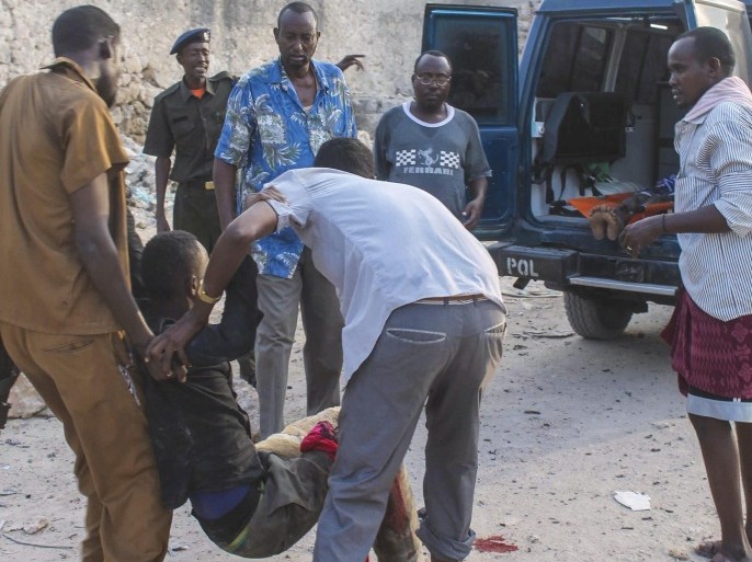 An injured man is evacuated from a scene of a car bomb explosion in front of a hotel in Mogadishu, Somalia, 27 March 2015. Reports say that a car bomb explosion followed by gunfire at a popular hotel in Mogadishu killed at least several people on 27 March. No one has claimed responsibility though scuh attacks in Mogadishu are often carried out by Islamist militant group al-Shabab.