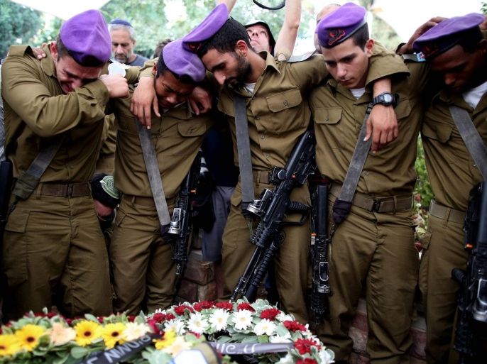 YEARENDER 2014 AUGUSTComrades cry next to the grave of Israeli soldier Lieutenant Hadar Goldin during a military funeral ceremony at the cemetery in Kfar Saba, Israel, 03 August 2014. Hadar Goldin was killed on 01 August 2014 in the Gaza Strip, during an attack by Palestinian militants in Rafah that occurred under 90 minutes into a humanitarian truce, the Israeli military said. Media reports that Hadar Goldin is a family relative of Israeli Defense Minister Moshe Ya'alon.