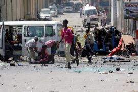 MOGADISHU, SOMALIA - APRIL 14 : Somali security forces evacuate injured and dead bombing victims from the scene of an explosion after a suicide bomber blew up his explosives-laden vehicle near the Education Ministry headquarters in Somali capital Mogadishu on April 14, 2015.