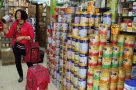 A Chinese visitor asks for the price of a canned infant formula at a store, in Hong Kong February 9, 2015. Visitors departing the territory are only allowed to take two cans of such milk powders, to stop cross-border traders. REUTERS/Liau Chung-ren (CHINA - Tags: BUSINESS SOCIETY FOOD)