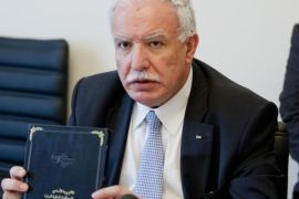 Palestinian Foreign Minister Riad Malki holds up a copy of the International Criminal Court's founding treaty, the Rome Statute, after a ceremony welcoming the Palestinians as the court's newest member in The Hague, Netherlands, Wednesday, April 1, 2015. Joining the court is part of a broader effort by the Palestinians to put international pressure on Israel and comes at a time when the chances of resuming negotiations on Palestinian statehood are seen as slim following Israeli Prime Minister Benjamin Netanyahu's recent election victory and tough campaign rhetoric. (AP Photo/Mike Corder)
