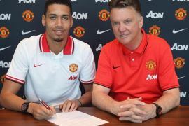 MANCHESTER, ENGLAND - APRIL 21: (EXCLUSIVE COVERAGE) Chris Smalling of Manchester United (L) poses with manager Louis van Gaal after signing a contract extension at Aon Training Complex on April 21, 2015 in Manchester, England.
