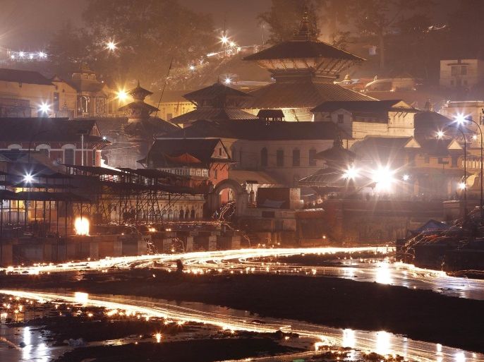Oil lamps offered by devotees illuminate the Bagmati River flowing through the premises of the Pashupatinath Temple, during the Bala Chaturdashi festival, in Kathmandu, November 21, 2014. The festival is celebrated by the worshippers by lighting oil lamps and scattering seven types of grains known as "sat biu" honouring the departed along a route at the temple. REUTERS/Navesh Chitrakar (NEPAL - Tags: RELIGION SOCIETY TPX IMAGES OF THE DAY)