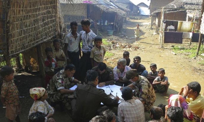 In this Nov. 10, 2012 photo, immigration officers fill out forms during an operation to verify the citizenship of Muslims living in the western Myanmar village of Sin Thet Maw. The government launched the checks on Nov. 8 after unrest broke out in June between ethnic Rakhine Buddhists and Rohingya Muslims they view as foreigners from Bangladesh.