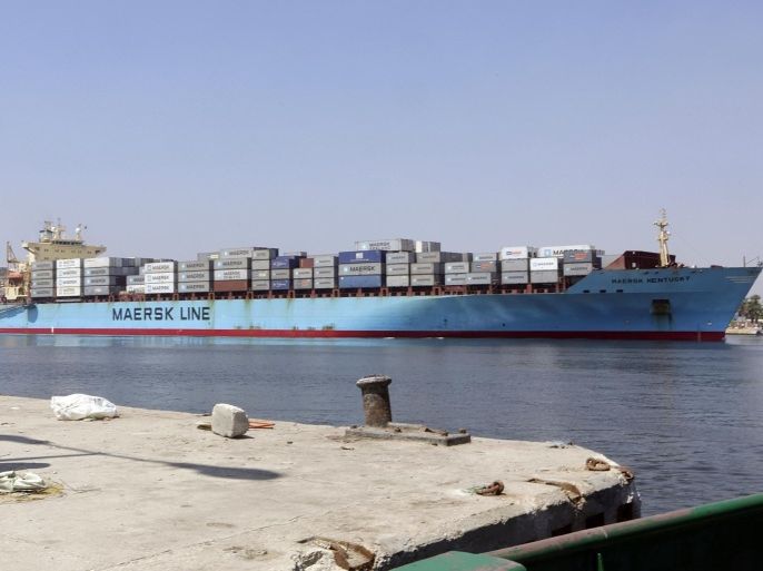 FILE - In this Tuesday, Aug. 12, 2014 file photo, an Egyptian soldier stands guard near the Suez Canal as an American container ship crosses the Suez Canal in Ismailia, Egypt. Egypt selected a consortium of Egyptian and the Persian Gulf companies to develop the government's mega project to transform the Suez Canal waterway into a hub of international investment and free trade zones, officials said on Tuesday, Aug. 19, 2014.(AP Photo/Amr Nabil, File)