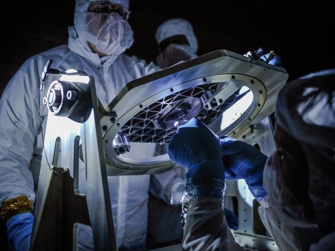 An undated handout picture made available by NASA on 08 September 2014 shows NASA engineers inspecting a new piece of technology developed for the James Webb Space Telescope, the micro shutter array, with a low light test at NASA's Goddard Space Flight Center in Greenbelt, Maryland, USA. Developed at Goddard to allow Webb's Near Infrared Spectrograph to obtain spectra of more than 100 objects in the universe simultaneously, the micro shutter array uses thousands of tiny shutters to capture spectra from selected objects of interest in space and block out light from all other sources. The James Webb Space Telescope is a large space telescope, optimized for infrared wavelengths. It is scheduled for launch later in this decade. Webb will find the first galaxies that formed in the early universe, connecting the Big Bang to our own Milky Way galaxy. Webb will peer through dusty clouds to see stars forming planetary systems, connecting the Milky Way to our own solar system. EPA/NASA GODDARD/CHRIS GUNN