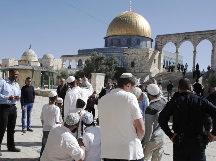 Jewish visitors stand outside the Dome of the Rock mosque at the al-Aqsa mosque compound in Jerusalem as they enter the area under Israeli security forces protection on April 5, 2015. AFP PHOTO / AHMAD GHARABLI