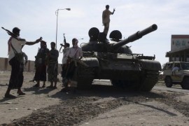 Militia men loyal to Yemen's President Abd-Rabbu Mansour Hadi take photos near an army tank in Yemen's southern port city of Aden March 19, 2015. An unidentified warplane attacked the presidential palace in Aden on Thursday after rival forces fought the worst clashes in years in Yemen's second city, an official and residents said, in a sharp escalation of the country's months-long conflict. REUTERS/Stringer