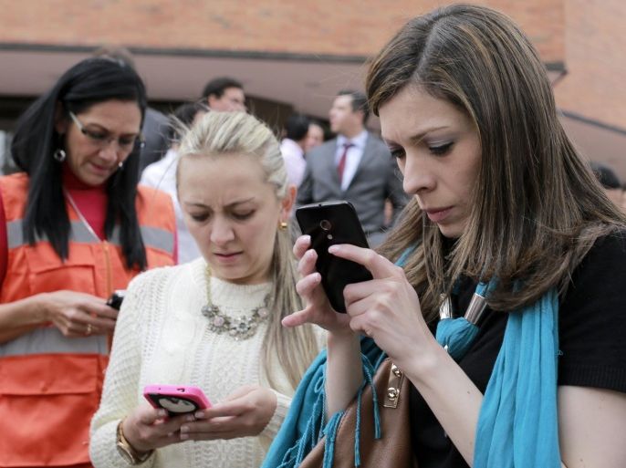 Women use their smart phones after the building where they work in Bogota was evacuated due to an earthquake that shook eastern Colombia causing buildings to sway in the capital Tuesday, March 10, 2015. The quake had a magnitude of 6.2 and was centered near the city of Bucaramanga, about 175 miles (280 kilometers) north of Bogota, according to the U.S. Geological Survey. There were no immediate reports of damage or injuries. (AP Photo/Ricardo Mazalan)