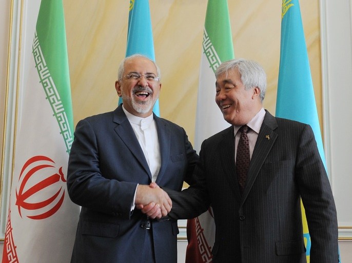 MOW1268 - Astana, -, KAZAKHSTAN : Kazakh Foreign Minister Yerlan Idrisov (R) shakes hands with his Iranian counterpart Mohammad Javad Zarif during their meeting in Astana on April 13, 2015. AFP PHOTO / ILYAS OMAROV