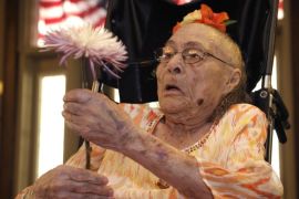 Gertrude Weaver holds a flower given to her a day before her 116th birthday, at Silver Oaks Health and Rehabilitation Center in Camden, Ark., Thursday, July 3, 2014. The Gerontology Research Group says Weaver is the oldest person in the United States and second-oldest person in the world. (AP Photo/Danny Johnston)