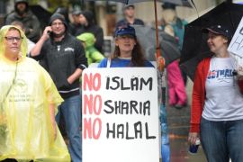 Protesters attend a Reclaim Australia rally to oppose religious extremism in Sydney on April 4, 2015. Protesters carried banners reading 'Yes Australia. No Islam' and 'No Muslim. No Sharia. No Halal' and braved wet weather to take part in a 'Reclaim Australia' protest in Sydney with organisers saying the 16 protests scheduled for around the country were protests against religious extremism. AFP PHOTO / Peter PARKS