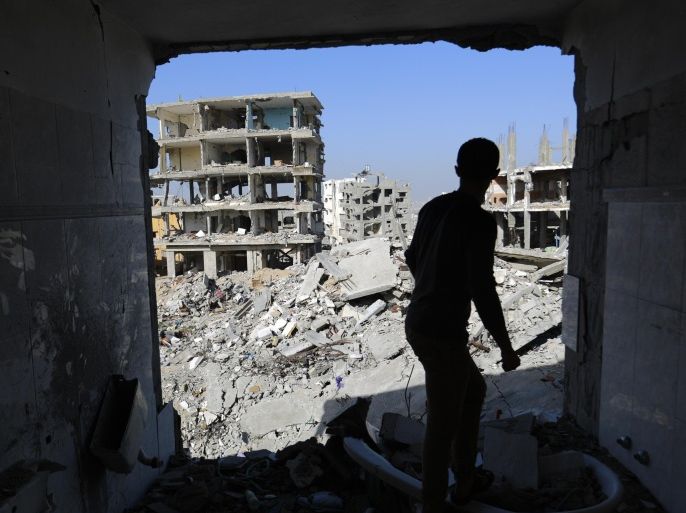 A Palestinian youth looks at rubble of houses which were damaged during the 50-day Gaza war between Israel and Hamas-led militants, on Decembre 10, 2014 in Gaza City. The Israeli military committed war crimes during its Gaza offensive this summer and must be investigated, human rights monitor Amnesty International yesterday. AFP PHOTO / MOHAMMED ABED