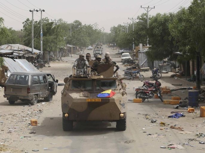 A convoy of soldiers from Niger and Chad drive down a looted street in the recently retaken town of Damasak, Nigeria, March 20, 2015. Soldiers from Niger and Chad who liberated the Nigerian town of Damasak from Boko Haram militants have discovered the bodies of at least 70 people, many with their throats slit, scattered under a bridge, a Reuters witness said. REUTERS/Emmanuel Braun TPX IMAGES OF THE DAY