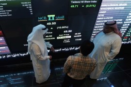 Investors monitor screens displaying stock information at the Saudi Stock Exchange (Tadawul) in Riyadh November 12, 2014. Shares in Saudi Arabia's biggest lender, National Commercial Bank, jumped their daily 10 percent limit upon listing on Wednesday after a $6 billion IPO, the largest ever in the Arab world and the second-biggest globally this year. REUTERS/Faisal Al Nasser (SAUDI ARABIA - Tags: BUSINESS)