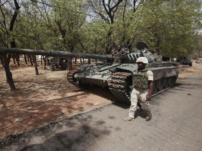 In this photo taken Wednesday, April 8, 2015, Nigerian soldiers man a check point in Gwoza, Nigeria, a town newly liberated from Boko Haram. Each day brings new reports of atrocities, with mass graves being discovered in towns seized back from the militants who had set up a so-called “Islamic caliphate” across a great swath of northeast Nigeria. Boko Haram's nearly 6-year-old Islamic uprising in northeast Nigeria that has killed thousands — a reported 10,000 just last year — and forced more than 1.5 million from their homes. (AP Photo/Lekan Oyekanmi)
