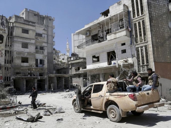 Rebel fighters inspect a site damaged by what activists said was shelling by warplanes loyal to Syria's President Bashar al-Assad in Jisr al-Shughour town, after the rebels took control of the area, April 26, 2015. Syrian jets carried out at least 20 air strikes on the town of Jisr al-Shughour in northwestern Syria on Sunday, a group monitoring the war said, one day after it was seized by Islamist fighters closing in on government-held territory by the coast. Syrian state television said the military had ambushed some militants close to Jisr al-Shughour, which was captured on Saturday for the first time in the four-year conflict by a hardline Islamist alliance including al-Qaeda. REUTERS/Khalil Ashawi TPX IMAGES OF THE DAY