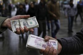 Iranian street money exchangers show currencies at Tehran's old main bazaar, Iran, Tuesday, Nov. 25, 2014. Iran's Supreme Leader said Tuesday that western powers will not be able to bring the country to its knees in nuclear talks, however he gave his indirect approval for a continuation of those negotiations. (AP Photo/Vahid Salemi)