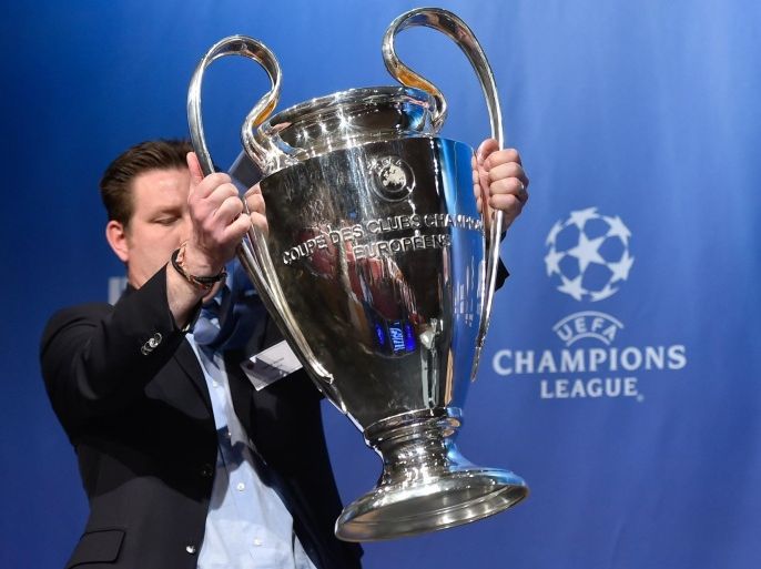 A UEFA logistics employee brings the UEFA Champions League trophy prior to the draw for the UEFA Champions League semi-final football matches at the UEFA headquarters in Nyon on April 24, 2015. AFP PHOTO / FABRICE COFFRINI