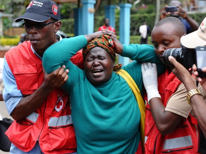 Kenya Red Cross staff assist a woman after she viewed the body of a relative killed in Thursday's attack on a university, at Chiromo funeral home, Nairobi, Kenya, Friday, April 3, 2015. Al-Shabab gunmen rampaged through a university in northeastern Kenya at dawn Thursday, killing scores of people in the group's deadliest attack in the East African country. Four militants were slain by security forces to end the siege just after dusk. (AP Photo)