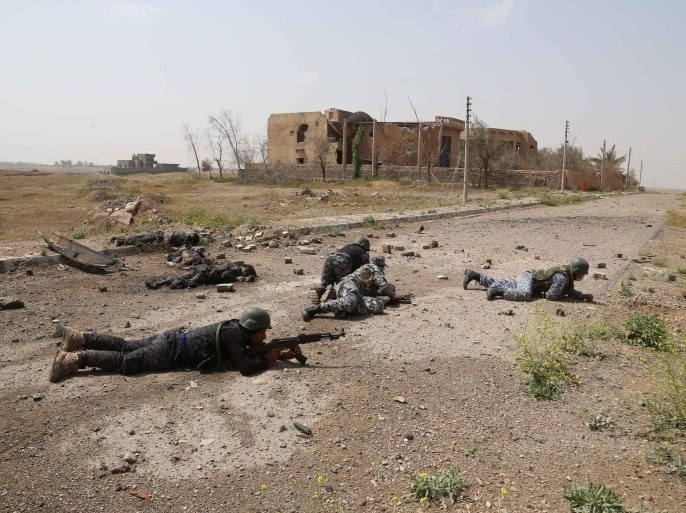 FILE - In this Monday, March 30, 2015 file photo, Iraqi security forces attack Islamic State extremists as they take up positions next to the bodies of Islamic State fighters in Tikrit, 80 miles (130 kilometers) north of Baghdad, Iraq. (AP Photo/Khalid Mohammed, File)