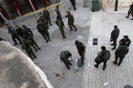Israeli security forces clean the pavement at the site where a Palestinian was shot dead after stabbing a border policeman on April 25, 2015 near the Tomb of Patriarchs in the West Bank city of Hebron. According to Israeli police spokeswoman Luba Samri, the border policeman was in moderate condition with stab wounds to his head and chest, while the 20-year-old suspected assailant died of his wounds on the way to a hospital in Jerusalem. AFP PHOTO / HAZEM BADER