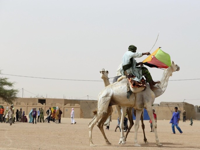 A Tuareg man holds the flag of the National Movement for the Liberation of Azawad (MLNA) during a demonstration in support of the MLNA on July 28, 2013 in Kidal, northern Mali. Malians defied Islamist death threats to vote on July 28 for a president expected to usher in a new dawn of peace and stability in the conflict-scarred nation. Voters have a choice of 27 candidates in the first election since last year's military coup upended one of the region's most stable democracies as Islamist militants hijacked a separatist uprising to seize a vast swathe in the desert north of the country. Clashes between Tuaregs and black Africans in the run-up to the election left four people dead. And gunmen thought to be from the MNLA kidnapped five polling officials 200 kilometres (125 miles) north of Kidal.