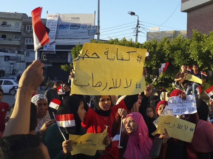 Demonstrators protest a three-month extension of the state of emergency and nightly curfew in the northern Sinai peninsula and acts of terrorism, in El-Arish, Sinai, Egypt, Saturday, April 25, 2015. Egypt has been battling an Islamic insurgency in northern Sinai for years, but attacks against army and police dramatically increased after the July 2013 ouster of Islamist President Mohammed Morsi. Main poster says, "Enough curfew, no to terrorism." (AP Photo/Muhamed Sabry)