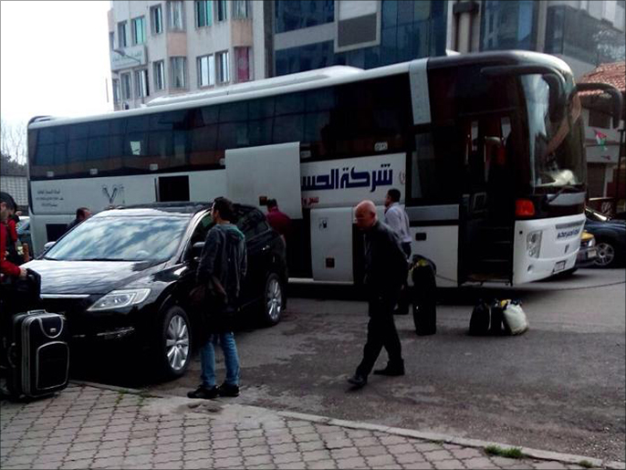 ‪الحافلة التي تقل قادة عسكريين قادمين من إدلب قرب مبنى الشرطة العسكرية‬ (الجزيرة)