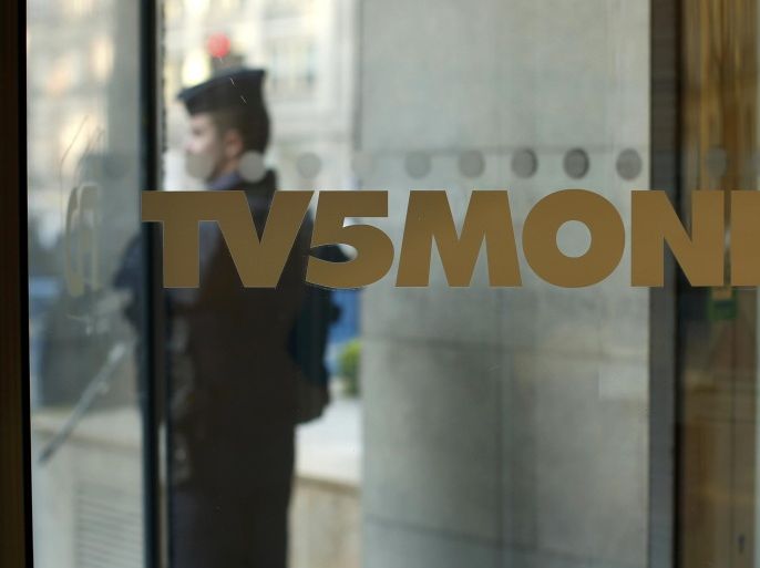 A French police officer stands guard in front of the main entrance of French television network TV5Monde headquarters in Paris April 9, 2015. French broadcaster TV5Monde was working on Thursday to regain control over its 11 channels and websites after an "extremely powerful" cyber attack claimed by the supporters of the Islamic State, its director said. REUTERS/Benoit Tessier