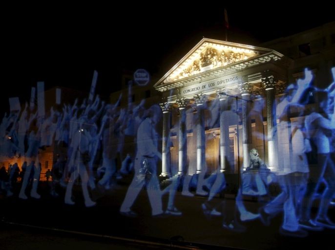 A projection of images of people demonstrating is seen outside Spain's Parliament during a protest against the Spanish government's new security law in Madrid April 10, 2015. The new security law toughens fines for unauthorised street protests. Critics consider it a violation of the right to protest and a limit to free expression and have labelled it "Ley Mordaza" (Gag Law). REUTERS/Susana Vera