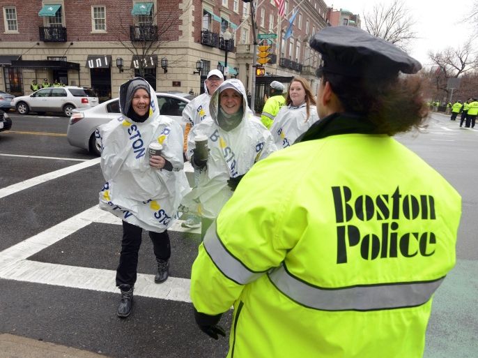 Boston, Massachusetts, UNITED STATES : BOSTON, MA - APRIL 20: A group of people in panchos walk past a Boston Police officer on Commonwealth Avenue near Kenmore Square as the Boston Marathon prepares to get underway April 20, 2015 in Boston, Massachusetts. This is the 119th running of the Boston Marathon. Darren McCollester/Getty Images/AFP
