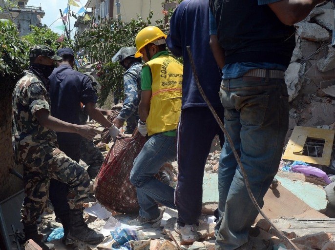 Nepalese police retrieve the body of earthquake victim Prasamsah, 14, during rescue efforts in Balaju in Kathmandu on April 27, 2015. International aid groups and governments intensified efforts to get rescuers and supplies into earthquake-hit Nepal on April 26, 2015, but severed communications and landslides in the Himalayan nation posed formidable challenges to the relief effort. As the death toll surpassed 2,000, the US together with several European and Asian nations sent emergency crews to reinforce those scrambling to find survivors in the devastated capital Kathmandu and in rural areas cut off by blocked roads and patchy phone networks. AFP PHOTO/PRAKASH SINGH