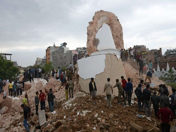 PRA421 - Kathmandu, -, NEPAL : Nepalese rescue members and onlookers gather at the collapsed Darahara Tower in Kathmandu on April 25, 2015. A powerful 7.9 magnitude earthquake struck Nepal, causing massive damage in the capital Kathmandu with strong tremors felt across neighbouring countries. AFP PHOTO / PRAKASH MATHEMA
