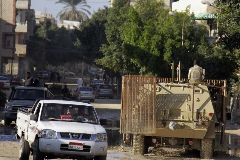 An armored personnel carrier drives past vehicles as the army demolish homes on the Egyptian side of border town of Rafah, northeast of Cairo, Egypt, Thursday, Nov. 6, 2014. In the deadliest-ever militant attack on the military, at least 30 soldiers were killed late last month in Sinai, prompting el-Sissi to declare a state of emergency in northern Sinai and order the eviction of some 10,000 people from the town of Rafah on the border with the Gaza Strip. (AP Photo/El Shorouk newspaper, Ahmed Abd El-Latif) EGYPT OUT