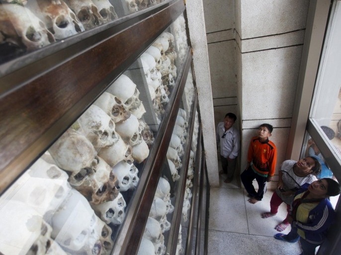 People look at skulls and bones of more than 8,000 victims of the Khmer Rouge regime during a Buddhist ceremony at Choeung Ek, a "Killing Fields" site located on the outskirts of Phnom Penh, April 17, 2015. Hundreds of Cambodians and monks gathered at the site to commemorate the 40th anniversary of the Khmer Rouge reign, which plunged the nation into a radical communist group genocide regime from 1975-1979. REUTERS/Samrang Pring