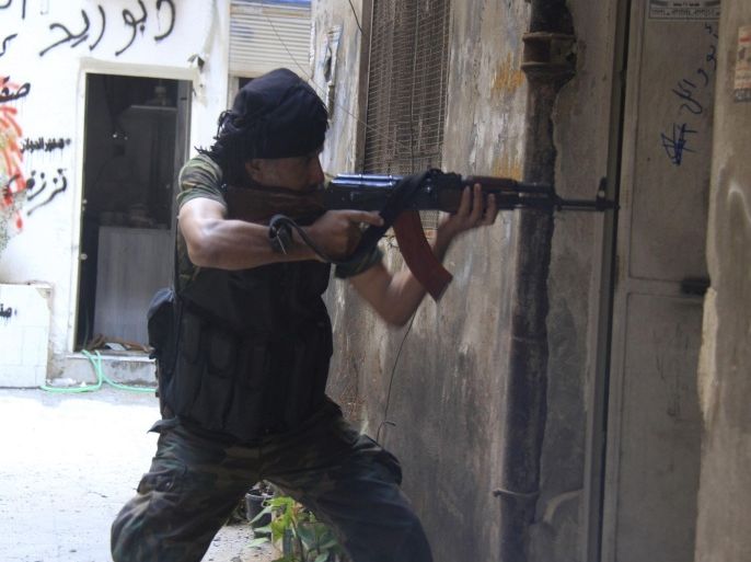 A Free Syrian Army fighter aims his weapon as he takes a defensive position in the refugee camp of Yarmouk, near Damascus September 11, 2013. Picture taken September 11, 2013. REUTERS/Ward Al-Keswani (SYRIACONFLICT - Tags: POLITICS CIVIL UNREST) CONFLICT)