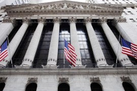 FILE - In this Feb. 10, 2011 file photo, American flags fly in front of the New York Stock Exchange, in New York. Asian stock markets were mostly higher Tuesday, Aug. 12, 2014, as tensions over Ukraine and Iraq eased, giving investors the confidence to dip into riskier assets. European shares drifted. (AP Photo/Mark Lennihan, File)