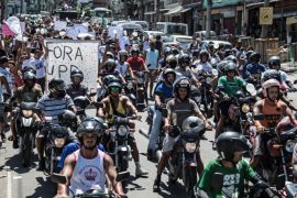 People on motorbikes participate in a 'march for peace' at Rio de Janeiro's Alemao favela on April 4, 2015 to protest against the death of a ten-year-old boy shot dead by the Brazilian police during a confrontation with drug traffickers two days ago. The child's killing in Rio's sprawling Alemao favela triggered angry protests on Friday which saw violent clashes with police and which have renewed security concerns ahead of next year's Olympics. Several hundred demonstrators turned out again on Saturday carrying white placards demanding an end to violence and a withdrawal of police from the favelas. Four people have died and three more have been wounded in a little over 24 hours of violence in Rio. AFP PHOTO / CHRISTOPHE SIMON