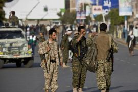 Shiite rebels known as Houthis wearing military uniforms stand guard on a street as their comrades protest against Saudi-led airstrikes, during a rally in Sanaa, Yemen, Wednesday, April 1, 2015. Saudi-led coalition warplanes bombed Shiite rebel positions in both north and south Yemen early Wednesday, setting off explosions and drawing return fire from anti-aircraft guns. (AP Photo/Hani Mohammed)