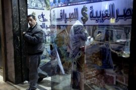An Egyptian man leaves after changing foreign currency at a currency exchange office, Arabic reads, "Arabian Egypt for Exchange," in Cairo, Egypt, Sunday, Jan. 6, 2013. Egypt swore in 10 new ministers on Sunday in a Cabinet shake-up aimed at improving the government's handling of the country's ailing economy ahead of talks this week with the International Monetary Fund over a badly needed $4.8 billion loan.