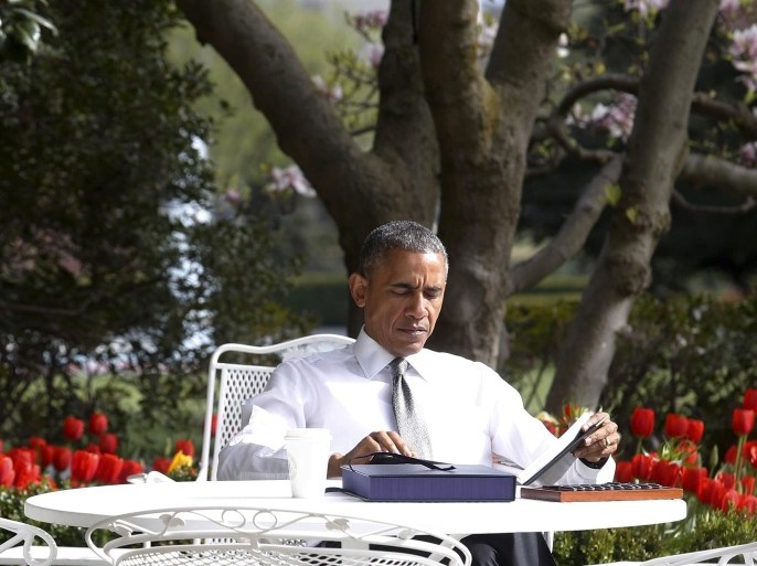 U.S. President Barack Obama reads papers at an outdoor table after signing the bill H.R. 2 Medicare Access and CHIP Reauthorization Act of 2015, the so-called Medicare 'doc fix,' in the Rose Garden at the White House in Washington April 16, 2015. REUTERS/Jonathan Ernst