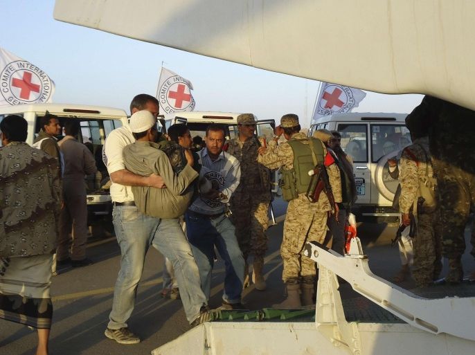 Red Cross medics carry a wounded man to a plane during an evacuation of injured people from Dammaj, in Yemen's northwestern province of Saada January 6, 2014. The International Committee of the Red Cross (ICRC) on Sunday evacuated 35 people wounded in the fighting between Salafists and Shi'ite Houthis in Dammaj, the relief agency said in a statement. REUTERS/Stringer (YEMEN - Tags: POLITICS CIVIL UNREST)