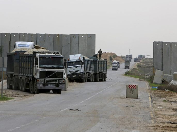 A Palestinian worker checks a truck loaded with construction materials at the Kerem Shalom border crossing on its way from Israel to Rafah in the southern Gaza Strip, Wednesday, Nov. 26, 2014. Egyptian authorities temporarily re-opened another border crossing with the Gaza Strip on Wednesday to allow Palestinians stranded outside the territory to return home, officials said. (AP Photo/Adel Hana)