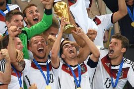 Philipp Lahm (C) of Germany lifts the World Cup trophy as his teammates Lukas Podolski (2-L) and Thomas Mueller (R) celebrate after the FIFA World Cup 2014 final between Germany and Argentina at the Estadio do Maracana in Rio de Janeiro, Brazil, 13 July 2014. Germany won 1-0 after extra time.(RESTRICTIONS APPLY: Editorial Use Only, not used in association with any commercial entity - Images must not be used in any form of alert service or push service of any kind including via mobile alert services, downloads to mobile devices or MMS messaging - Images must appear as still images and must not emulate match action video footage - No alteration is made to, and no text or image is superimposed over, any published image which: (a) intentionally obscures or removes a sponsor identification image; or (b) adds or overlays the commercial identification of any third party which is not officially associated with the FIFA World Cup) EPA/MARCUS BRANDT